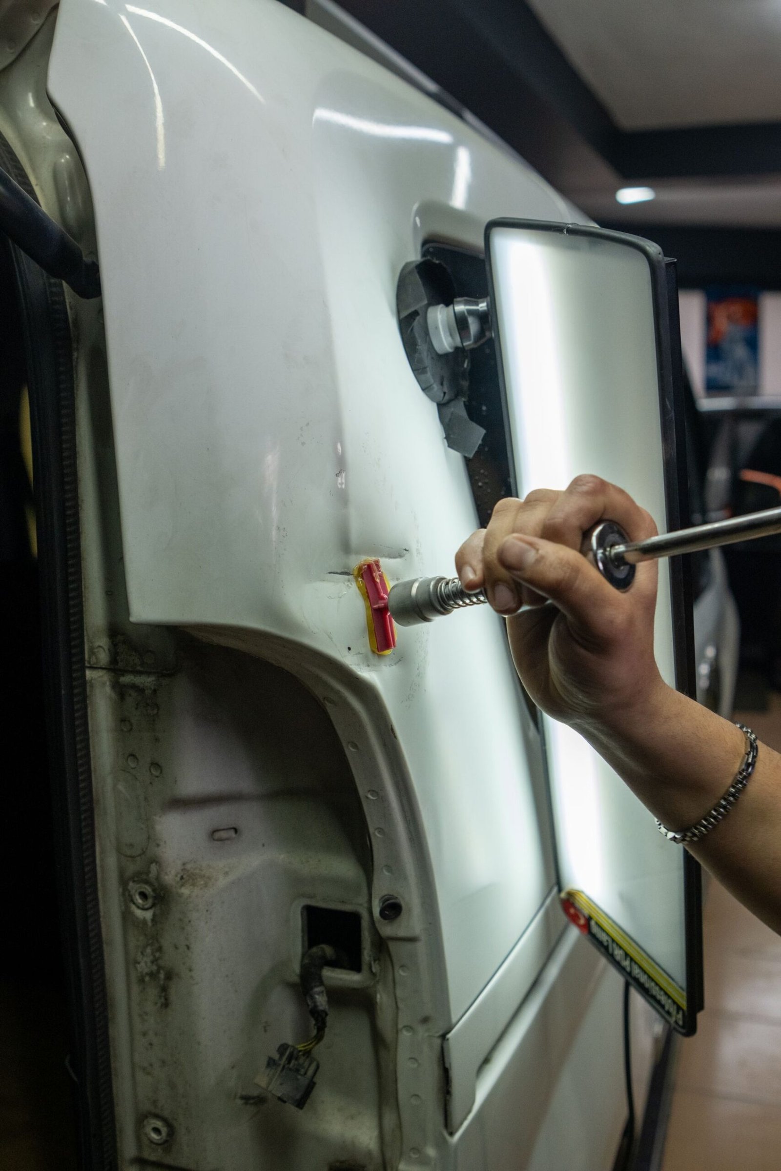 Close-up of dent repair being carried out on a vehicle body panel